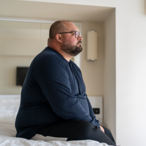 obese veteran sitting on his bed